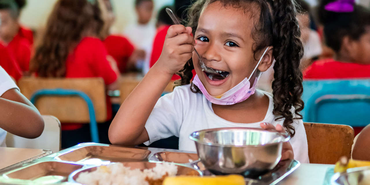 Photo showing a girl eating her WFP-provided lunch at a school in Falcón state, Venezuela.